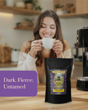 Woman holding a coffee cup with a Guatemala coffee bag labeled 'Dark. Fierce. Untamed' in a kitchen setting.